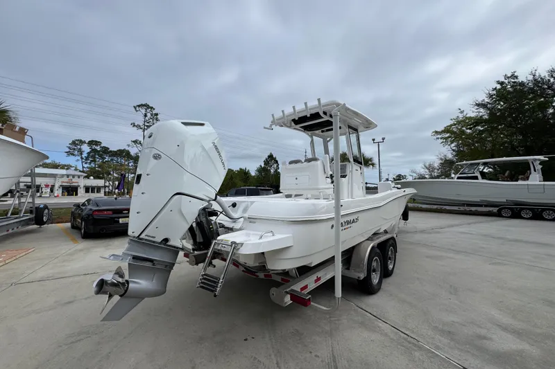 Slide: The Image of 2026 Caymas 26 HB boat on trailer with powerful outboard motor, parked outdoors. - 11