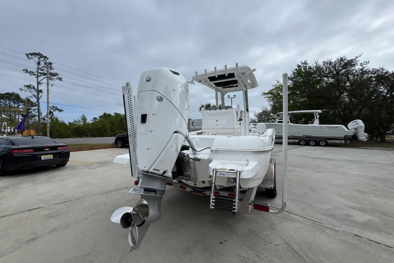 Slide: The Image of 2026 Caymas 26 HB boat with powerful outboard motor, parked on a trailer. - 12