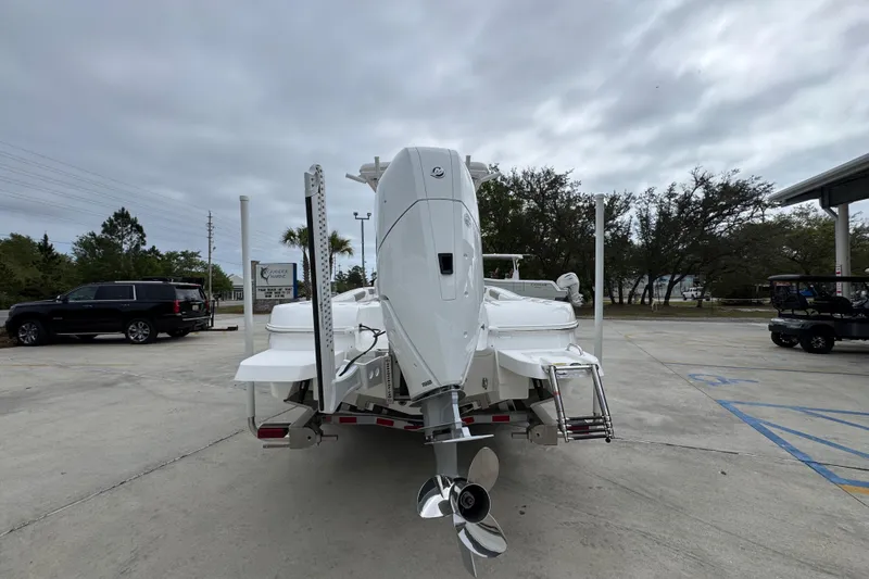 Slide: The Image of 2026 Caymas 26 HB boat with outboard motor in a parking lot. - 13