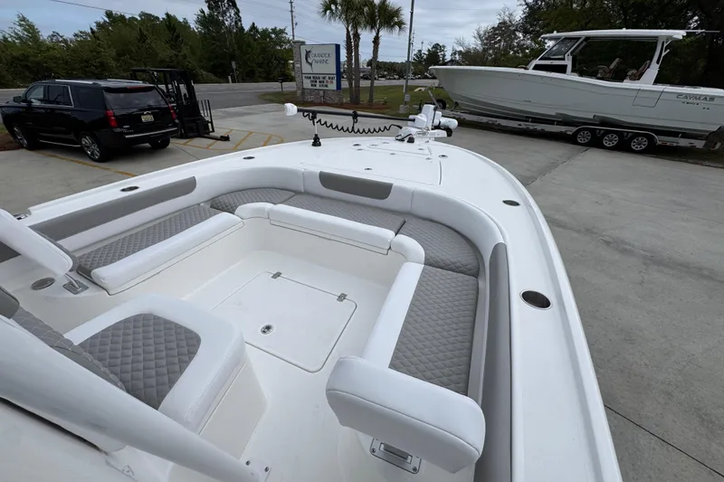 Slide: The Image of 2026 Caymas 26 HB boat with spacious seating, parked near a trailer and SUV. - 17