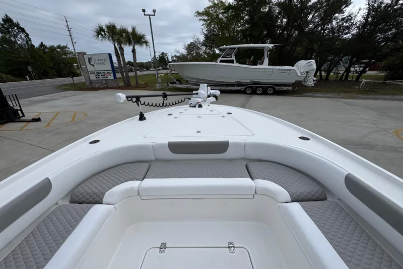 Slide: The Image of 2026 Caymas 26 HB boat with spacious seating and modern design in a marina setting. - 18