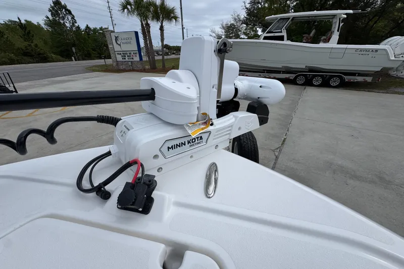 Slide: The Image of 2026 Caymas 26 HB boat with Minn Kota trolling motor, parked outdoors. - 20