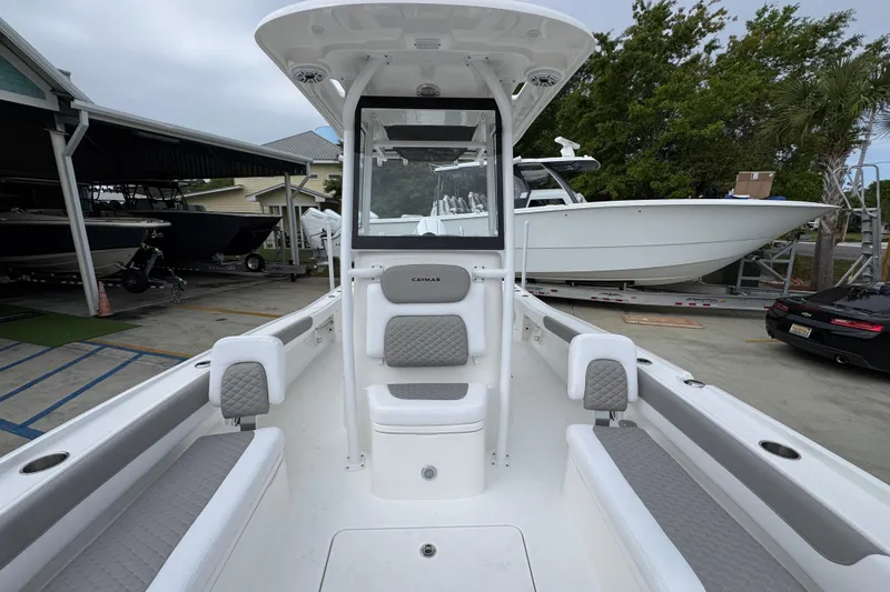 Slide: The Image of 2026 Caymas 26 HB boat interior with seating, docked near other boats. - 23