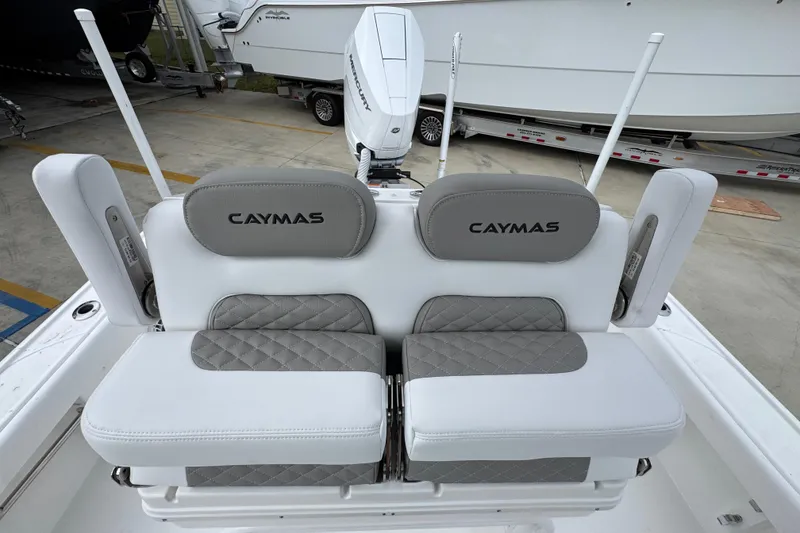 Slide: The Image of 2026 Caymas 26 HB boat seating with gray and white upholstery, featuring "Caymas" branding. - 28
