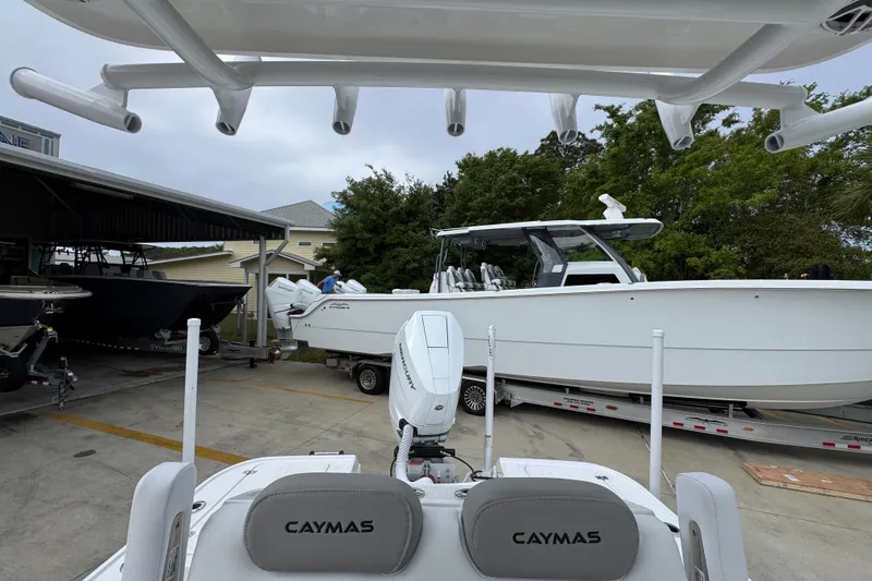 Slide: The Image of 2026 Caymas 26 HB boat on trailer, parked outdoors near other boats. - 29