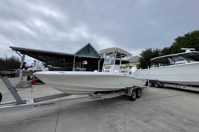 Slide: The Image of 2026 Caymas 26 HB boat on trailer, parked outdoors under cloudy sky. - 3