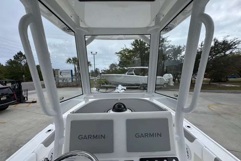 Slide: The Image of 2026 Caymas 26 HB boat interior with dual Garmin displays, parked outdoors. - 33
