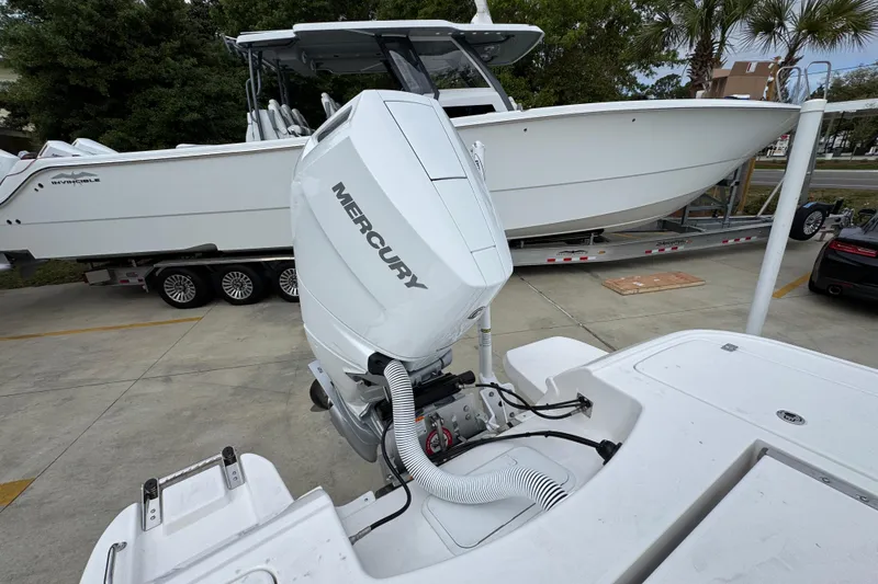 Slide: The Image of 2026 Caymas 26 HB boat with Mercury engine on trailer, parked outdoors. - 40