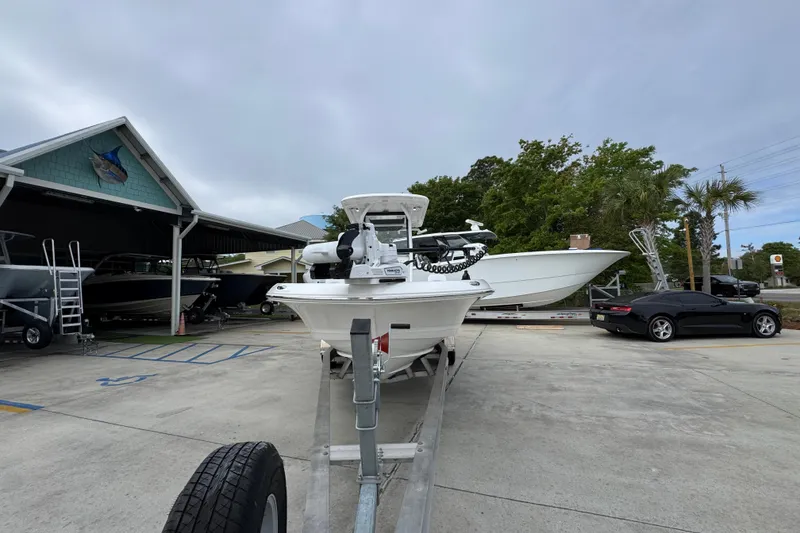 Slide: The Image of 2026 Caymas 26 HB boat on trailer at dealership, surrounded by other vehicles. - 5