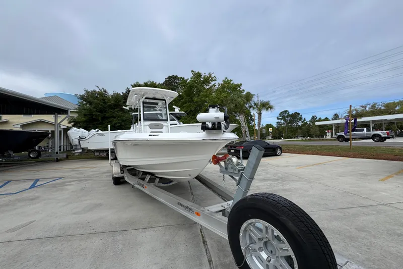 Slide: The Image of 2026 Caymas 26 HB boat on trailer in parking lot, overcast sky. - 6