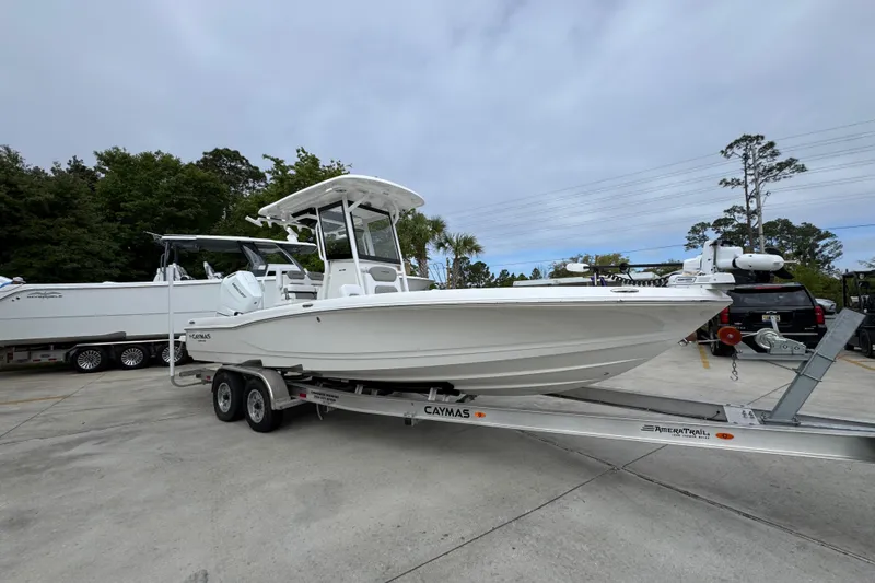 Slide: The Image of 2026 Caymas 26 HB boat on trailer, parked outdoors, showcasing sleek design. - 7
