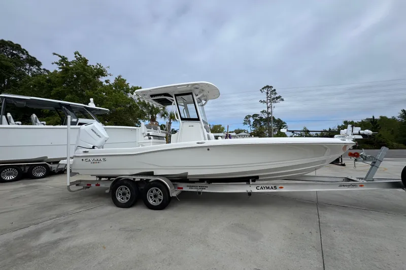 Slide: The Image of 2026 Caymas 26 HB boat on trailer, parked outdoors under cloudy sky. - 8