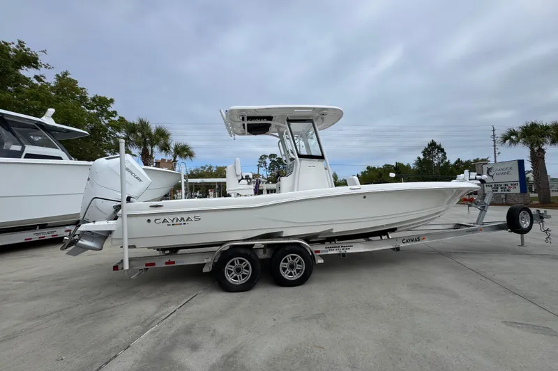Slide: The Image of 2026 Caymas 26 HB boat on trailer, parked outdoors, showcasing sleek design and powerful engine. - 9