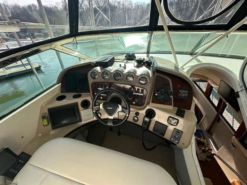 Slide: The Image of 2005 Carver 56 Voyager helm with navigation instruments and steering wheel, docked by the water. - 11