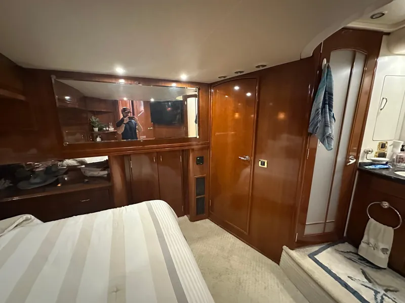 Slide: The Image of Luxurious interior of 2005 Carver 56 Voyager yacht bedroom with wood paneling and mirror. - 19