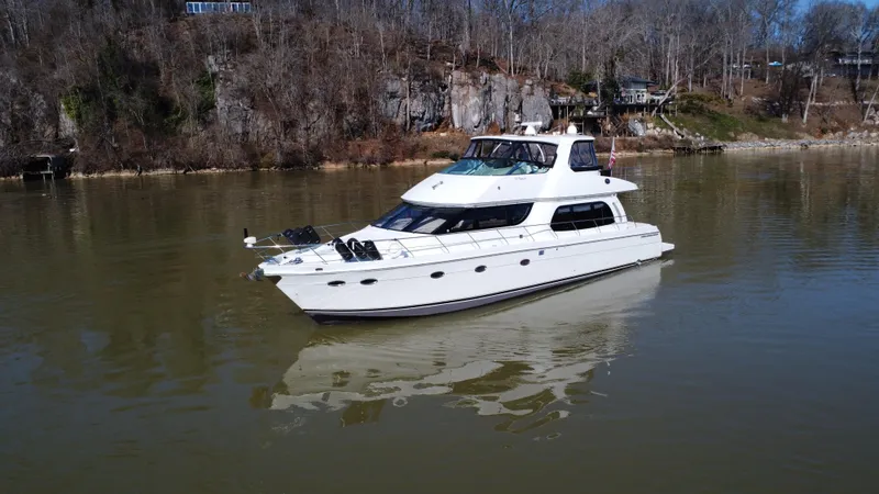 Slide: The Image of 2005 Carver 56 Voyager yacht on calm river with wooded shoreline. - 2