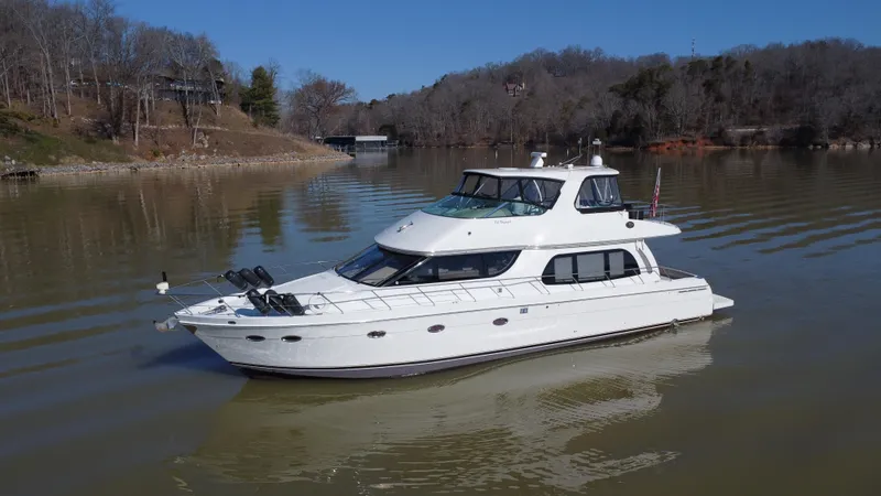 Slide: The Image of 2005 Carver 56 Voyager yacht on a calm lake with wooded shoreline. - 5