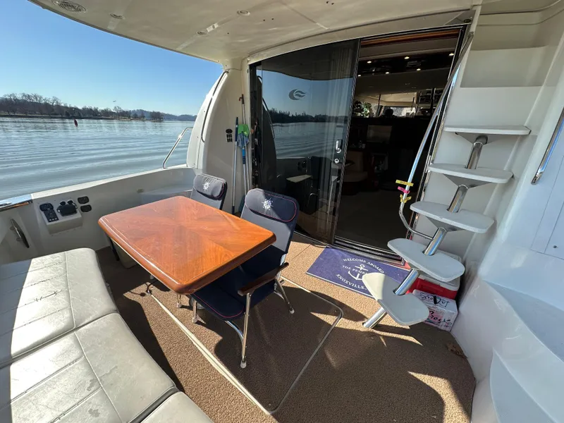 Slide: The Image of 2005 Carver 56 Voyager yacht interior with seating and table, overlooking serene water. - 6