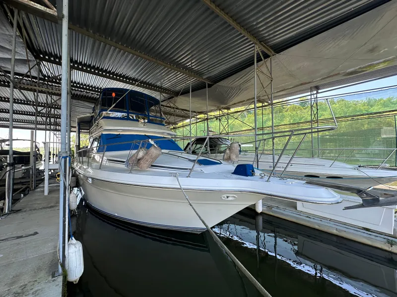 The Image of 1991 Sea Ray 380 Aft Cabin yacht docked in a covered marina. - 0