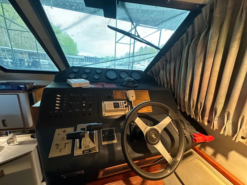 Slide: The Image of 1991 Sea Ray 380 Aft Cabin helm with steering wheel and control panel. - 12