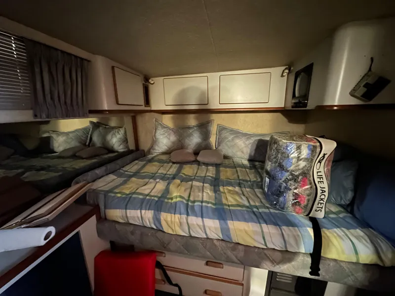 Slide: The Image of 1991 Sea Ray 380 Aft Cabin bedroom with bed, pillows, and life jackets. - 13