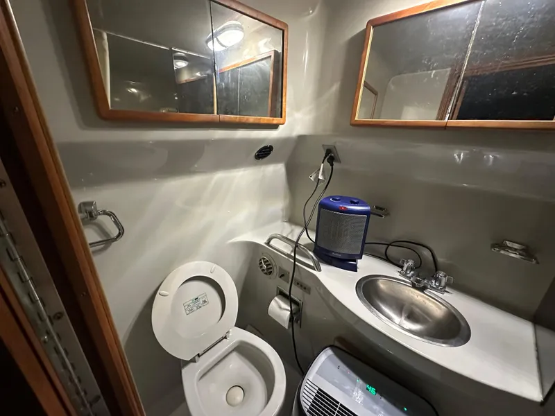 Slide: The Image of 1991 Sea Ray 380 Aft Cabin bathroom with toilet, sink, and mirror cabinets. - 15