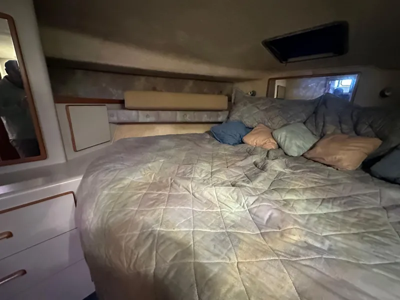 Slide: The Image of 1991 Sea Ray 380 Aft Cabin bedroom with cozy bedding and storage cabinets. - 6