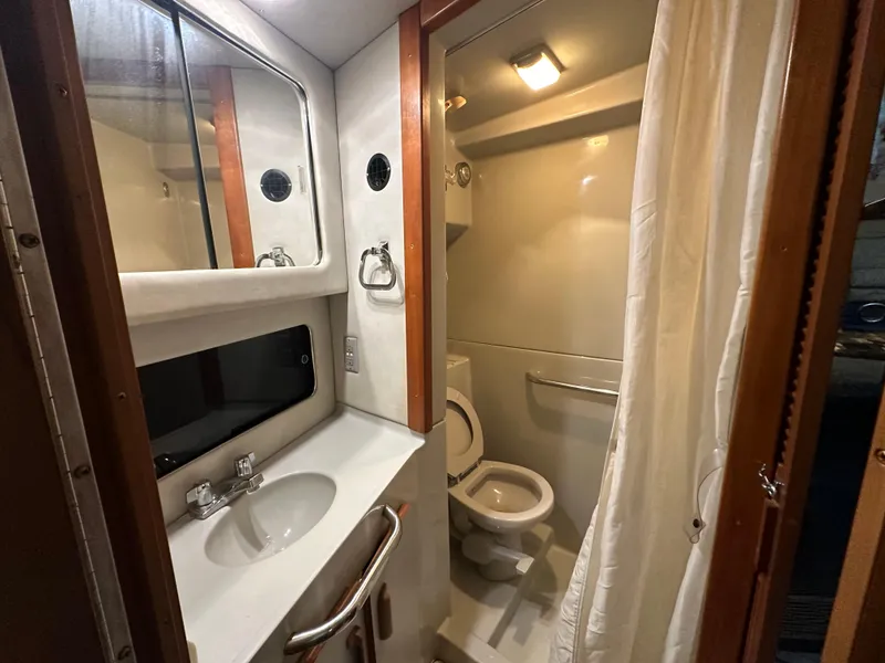 Slide: The Image of 1991 Sea Ray 380 Aft Cabin bathroom with sink, mirror, and toilet. - 7