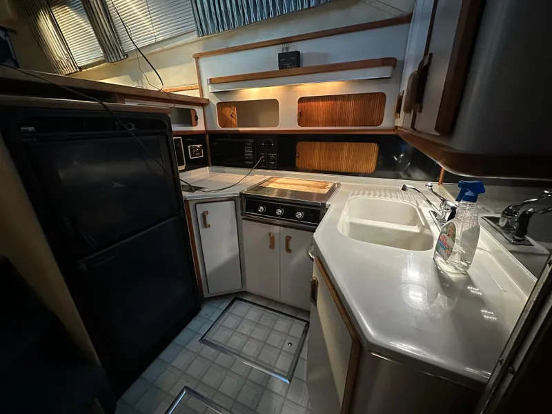 Slide: The Image of 1991 Sea Ray 380 Aft Cabin kitchen with stove, sink, and refrigerator. - 8