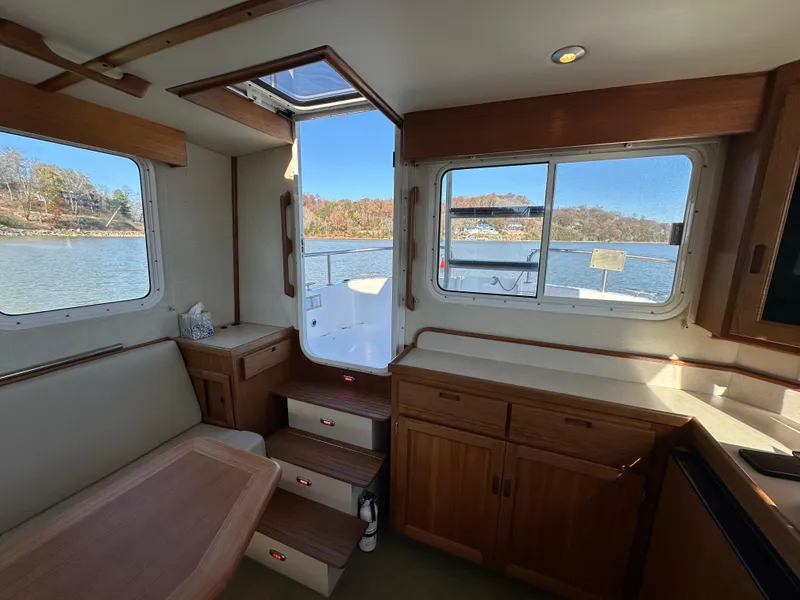 Slide: The Image of Interior of 2007 Nordic Tug 32 with wooden cabinetry and river view. - 12