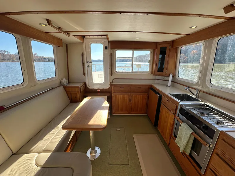 Slide: The Image of Interior of 2007 Nordic Tug 32 with kitchen and seating area, overlooking water. - 13