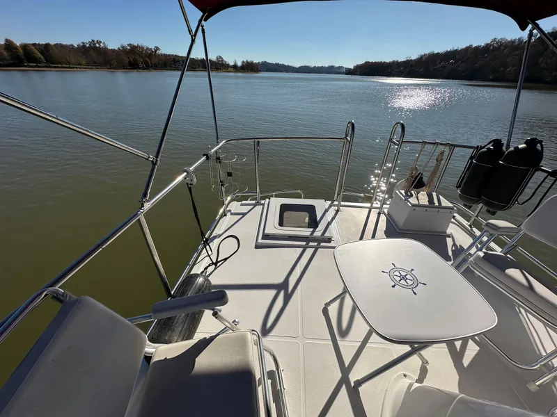 Slide: The Image of 2007 Nordic Tug 32 boat deck with seating, table, and scenic water view. - 21