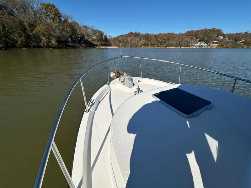 Slide: The Image of Nordic Tug 32 (2007) cruising on a calm lake with scenic shoreline. - 23