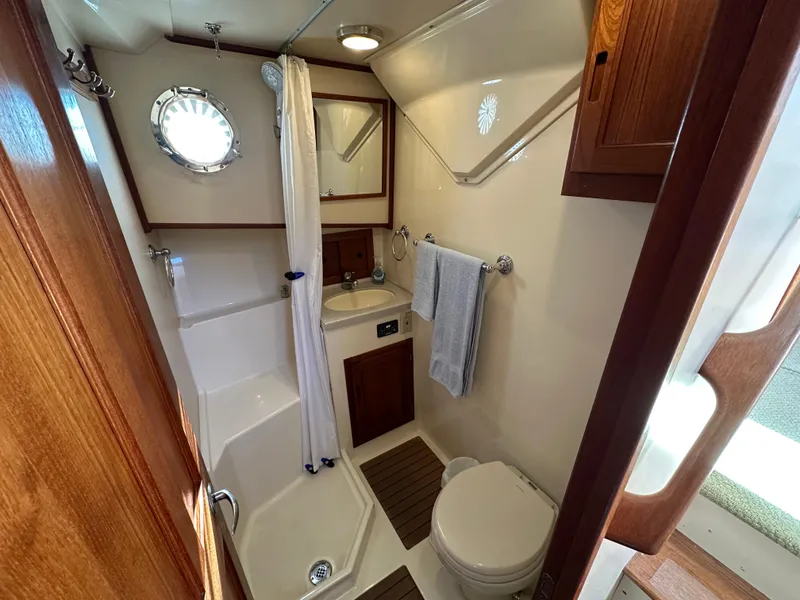 Slide: The Image of 2007 Nordic Tug 32 bathroom with shower, sink, and wooden accents. - 6