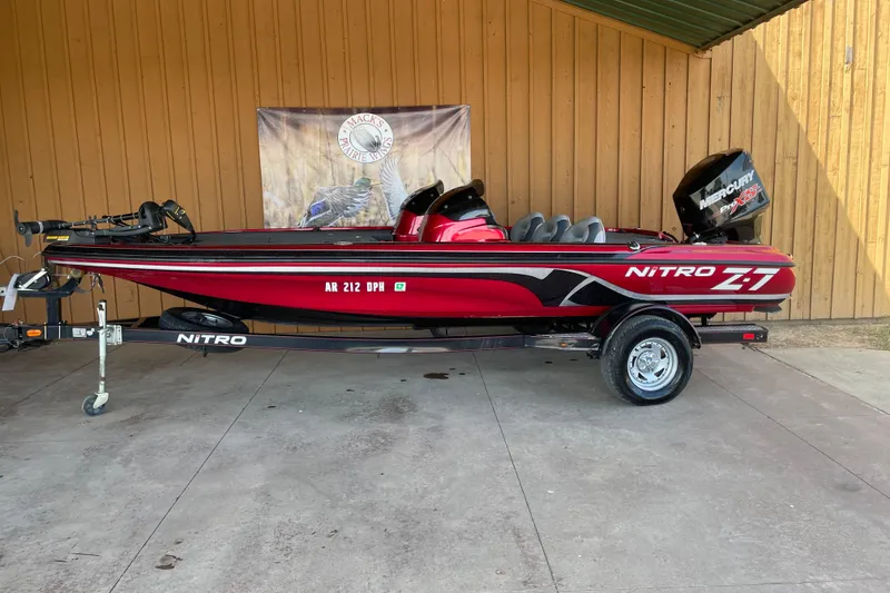 Slide: The Image of 2013 Nitro Z-7 red fishing boat on trailer, parked indoors. - 1