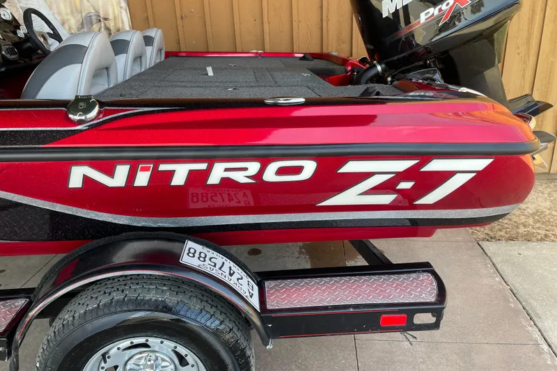 Slide: The Image of Red 2013 Nitro Z-7 boat with Mercury Pro XS engine, parked on trailer. - 2