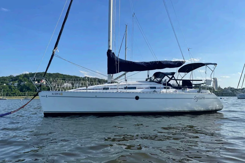 The Image of 1993 Beneteau First 310 sailboat on calm water under clear blue sky. - 0