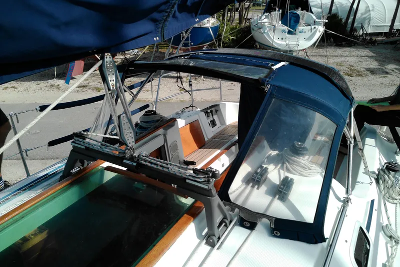 Slide: The Image of 1993 Beneteau First 310 sailboat with blue canopy and deck details. - 13