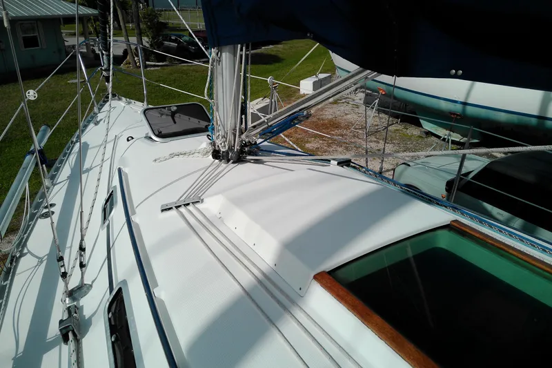 Slide: The Image of 1993 Beneteau First 310 sailboat deck with rigging and hatch, docked outdoors. - 14