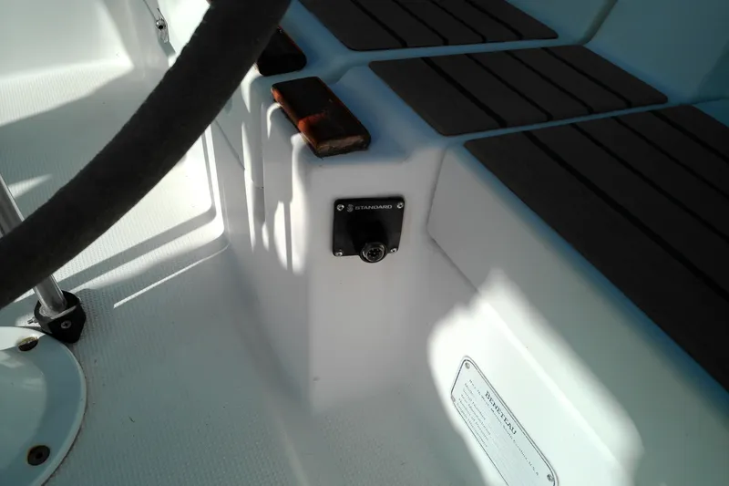Slide: The Image of Cockpit area of a 1993 Beneteau First 310 sailboat, featuring seating and a control panel. - 26
