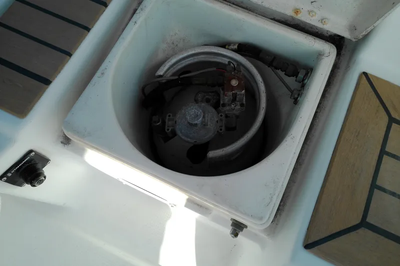 Slide: The Image of Compartment on 1993 Beneteau First 310 sailboat, featuring a gas cylinder and fittings. - 27