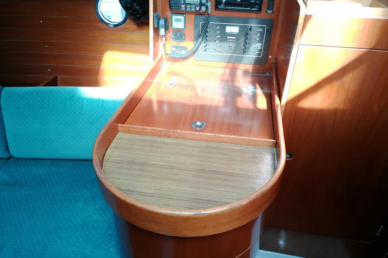 Slide: The Image of Interior of 1993 Beneteau First 310 sailboat with navigation station and teal seating. - 30