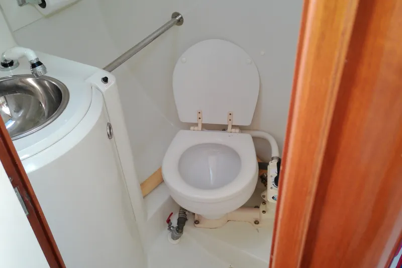 Slide: The Image of Compact bathroom in a 1993 Beneteau First 310 sailboat, featuring a toilet and sink. - 32