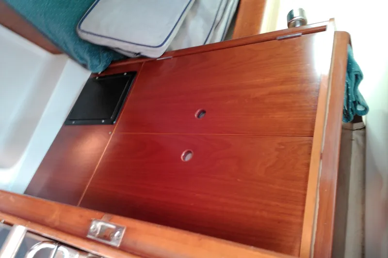 Slide: The Image of Interior view of a 1993 Beneteau First 310 sailboat, featuring wooden cabinetry and seating. - 35