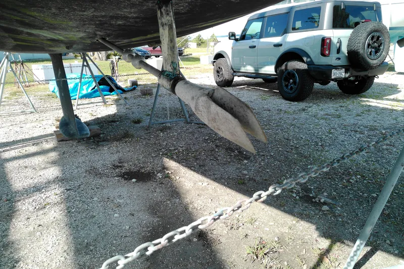 Slide: The Image of 1993 Beneteau First 310 sailboat on stands, with a vehicle in the background. - 4