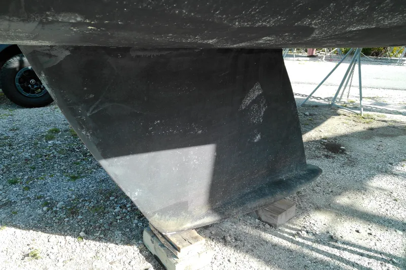 Slide: The Image of Close-up of a 1993 Beneteau First 310 keel on a gravel surface. - 5