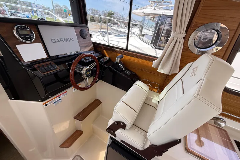 Slide: The Image of Interior helm of 2026 Ranger Tugs R-25 with Garmin navigation system and luxurious seating. - 11