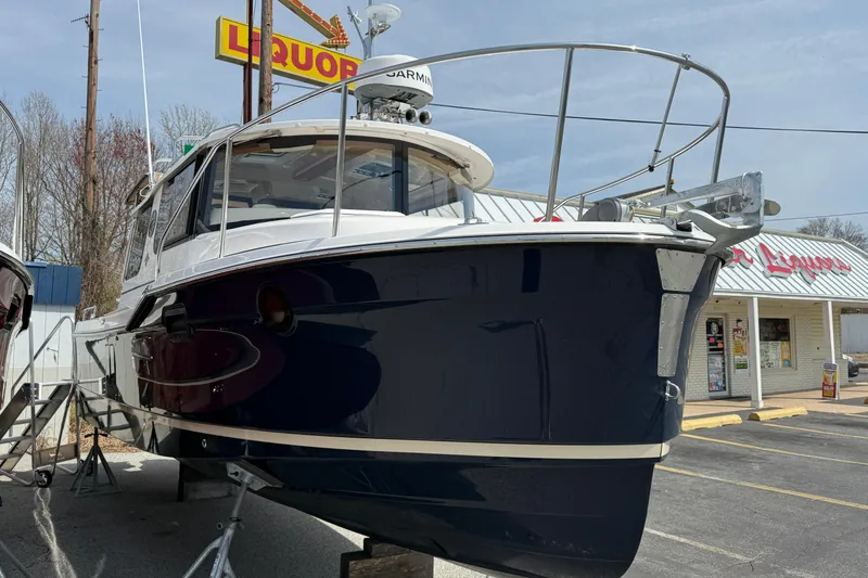 Slide: The Image of 2026 Ranger Tugs R-25 boat displayed near a liquor store, showcasing sleek design. - 3