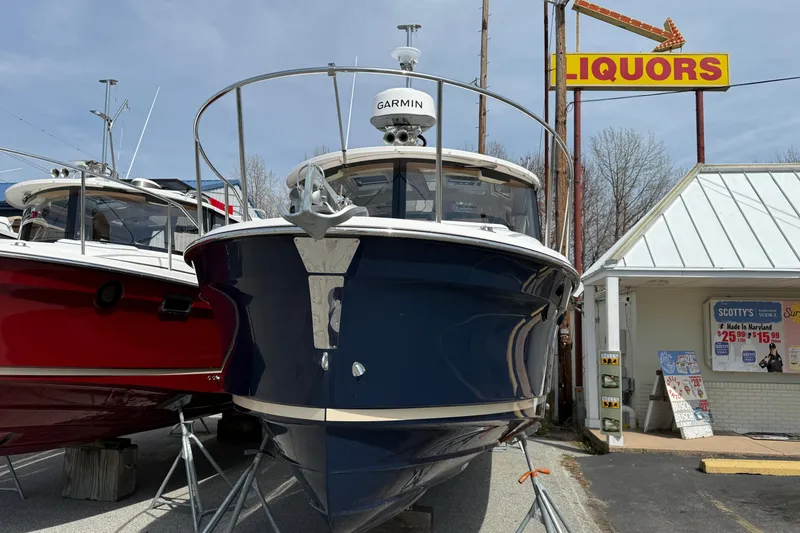 Slide: The Image of 2026 Ranger Tugs R-25 boat displayed outdoors near a liquor store. - 4