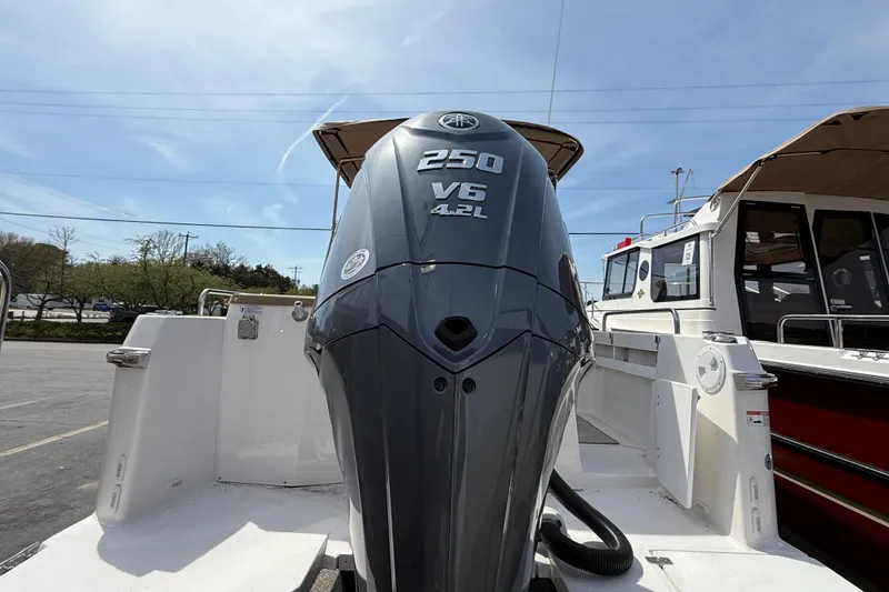 Slide: The Image of 2026 Ranger Tugs R-25 with powerful 250 V6 outboard engine, docked under clear skies. - 5